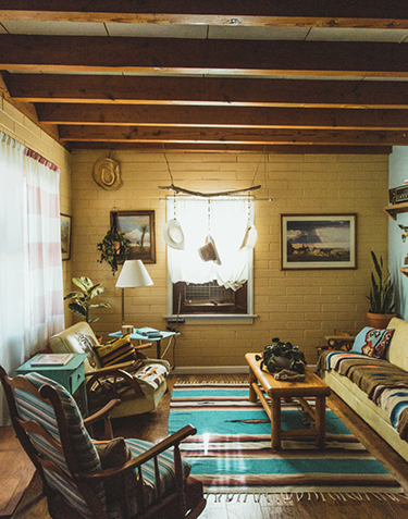 A rustic home with southwestern style decor, warm lighting, and exposed wooden beams.