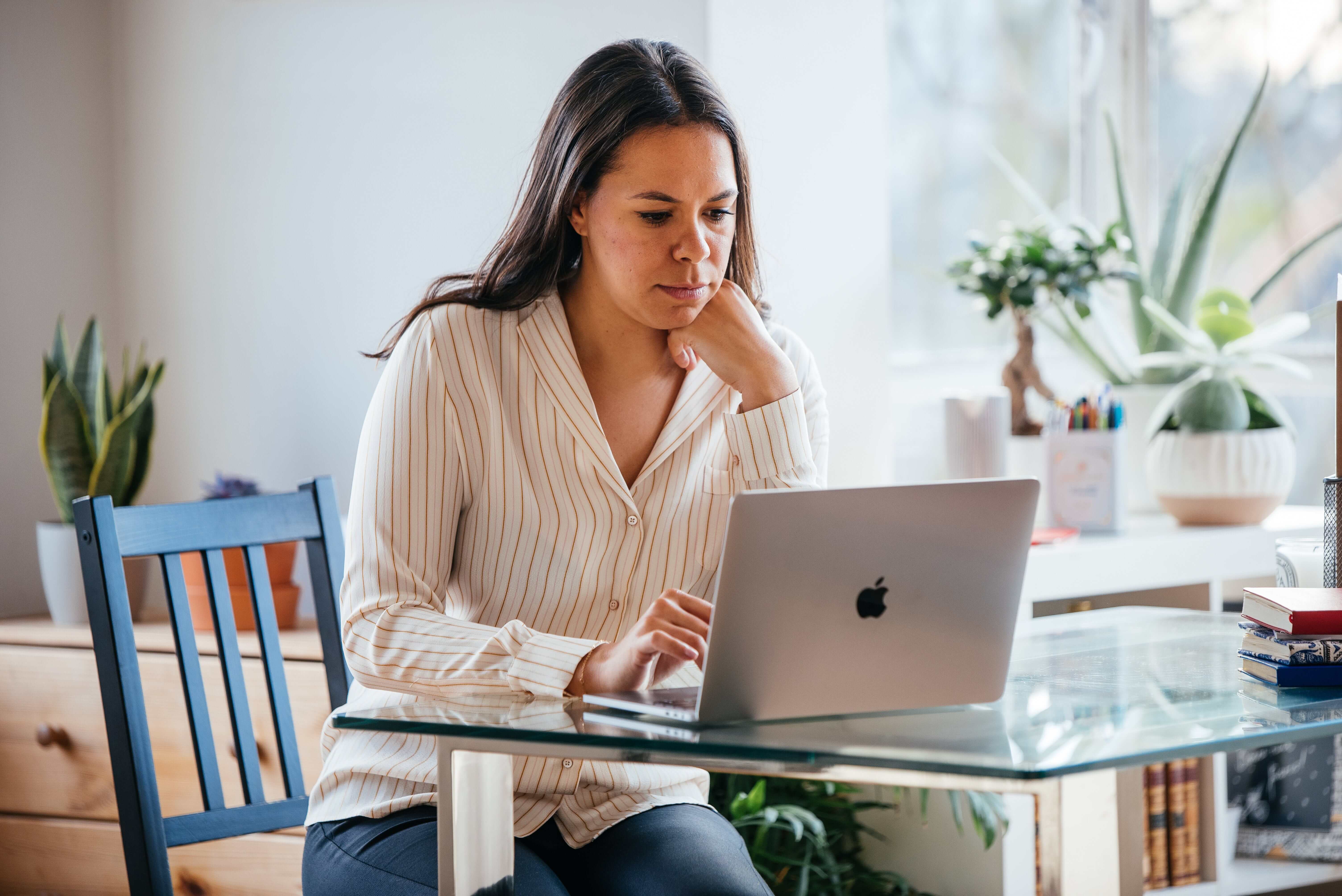 Khaleelah Jones sitting at a table, looking at her laptop screen.