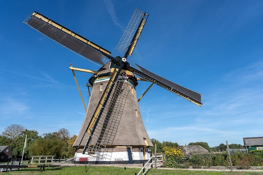 A modern windmill in excellent condition, against the background of a blue sky.